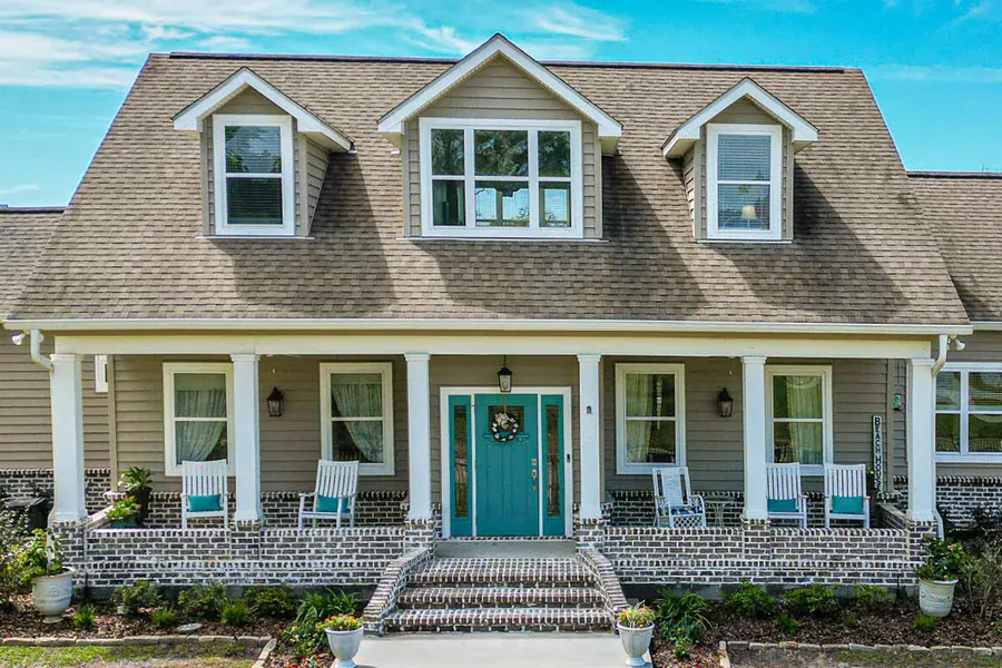 A raised Cape Cod style home with a front porch in Waveland, Mississippi